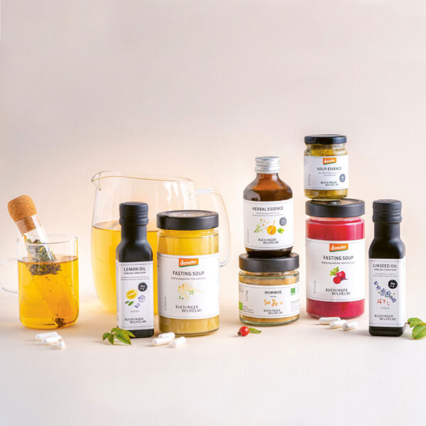 Bestandteile der Buchinger FASTENBOX mit Teesieb, Zitronenöl, Fastensuppe, Herbal Essence, Hummus, Soup Essence und Leinöl